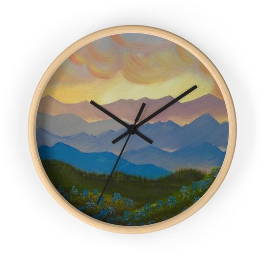 Discover Sunset Mountain Ranges and Grassy Hills with Blue/Purple Flowers Wall clock