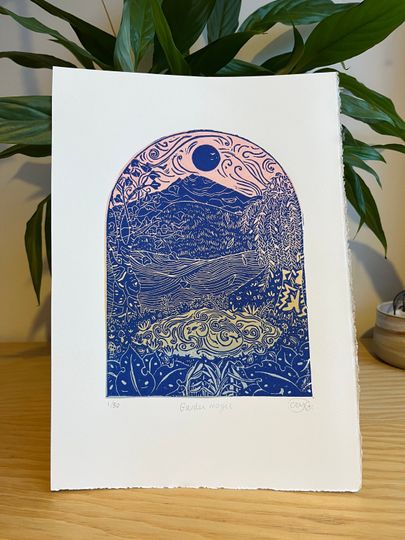 Discover Garden Magic, original limited edition handprinted lino print, block print illustration of landscape, mountains, trees, water in pink/ blue.